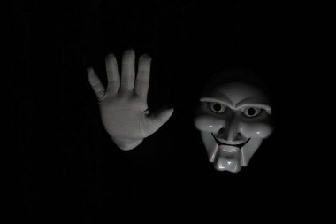 Siyah arka planda beyaz, korkunç bir maske..