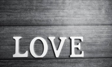 ahşap arka plan üzerinde beyaz tahta harflerle yapılan kelime aşk