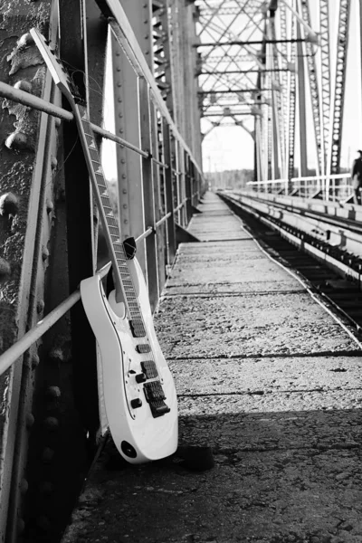 Guitarra eléctrica en blanco y negro en las vías del ferrocarril y piedra — Foto de Stock