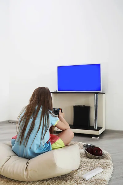 Młoda dziewczyna gry przed telewizorem — Zdjęcie stockowe