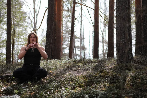 Doğada bir araçla bir müzisyen. Bir adam bir flüt çalıyor bir 