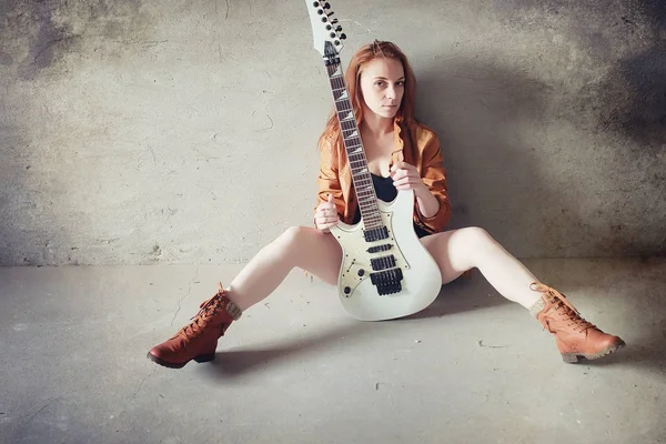 Giovane ragazza dai capelli rossi con una chitarra elettrica. Musicista rock gir — Foto Stock