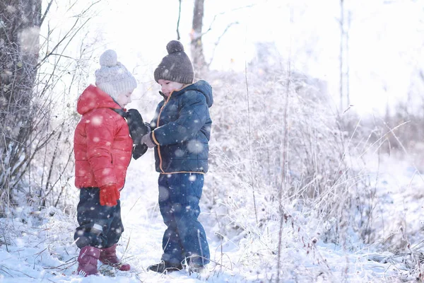 Los niños caminan en el parque primera nieve —  Fotos de Stock