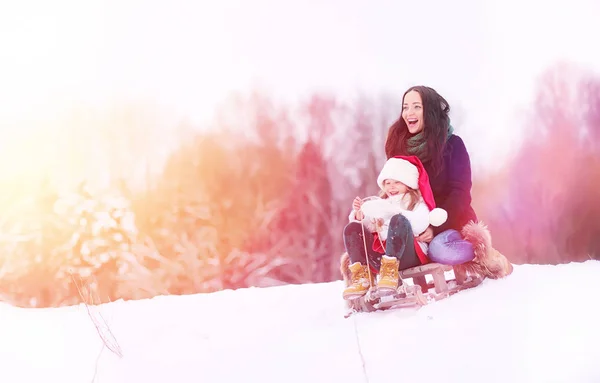 Zimní pohádka, mladá matka a její dcera jezdit na saních — Stock fotografie