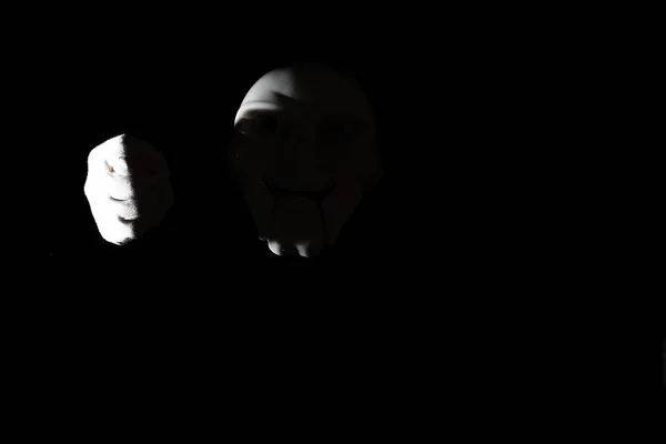 Vit skrämmande mask på en svart bakgrund med vita handen. — Stockfoto