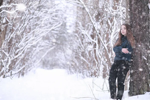 Girl in a winter park in snowfall — Stok Foto