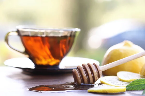 Frischer Honig mit einer Tasse Schwarztee — Stockfoto