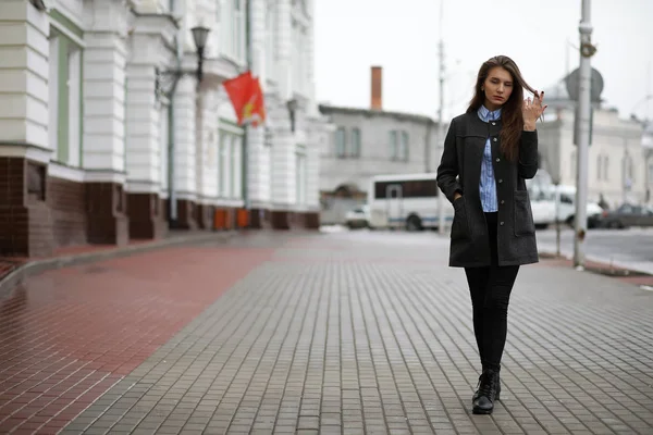 Giovane ragazza adulta in cappotto sulla strada — Foto Stock