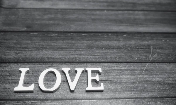 Word love made up of white wooden letters on a wooden background — Stock Photo, Image