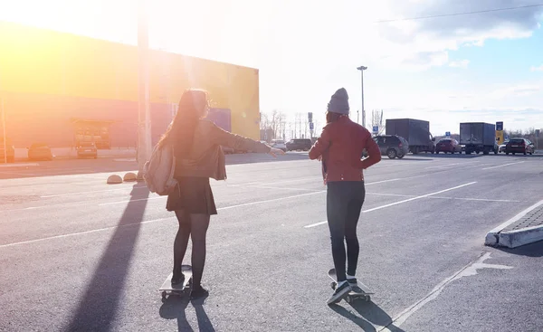 Una giovane hipster sta cavalcando uno skateboard. Ragazze amiche f — Foto Stock