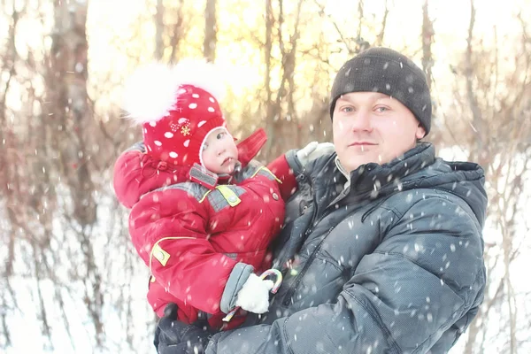 Father with daughter in the park in winter snow blizzard