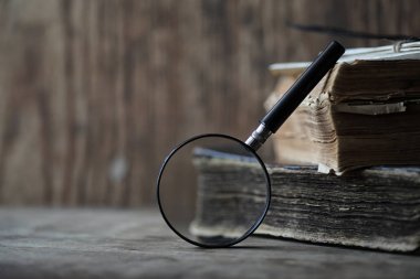 Ahşap bir masa ve cam magnifie üzerinde eski kitaplar