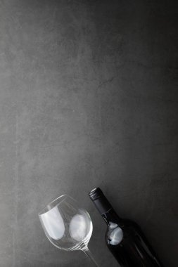 Taş zeminde kırmızı şarap. Şarap kadehi ve siyah şarap şişesi. Fındık peynir ve domates snack için.