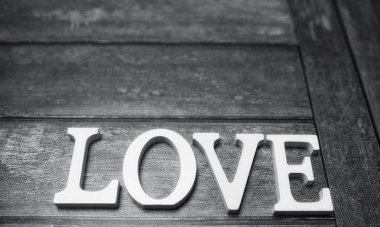 ahşap arka plan üzerinde beyaz tahta harflerle yapılan kelime aşk