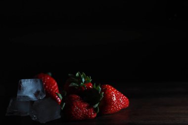 Tahta bir masada taze olgun çilekler.