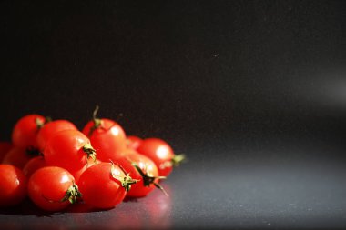Sprey siyah bir arka plan üzerinde Kiraz domates