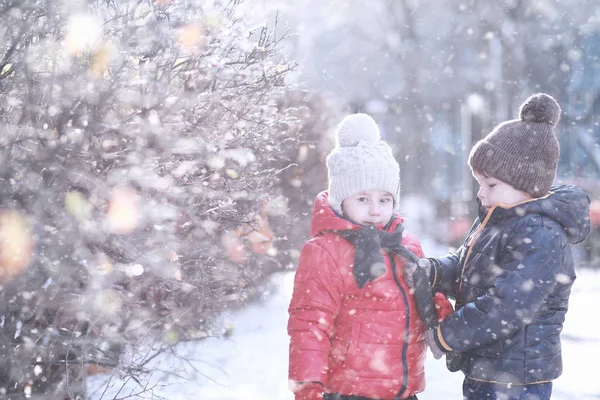 Les enfants marchent dans le parc première neige — Photo