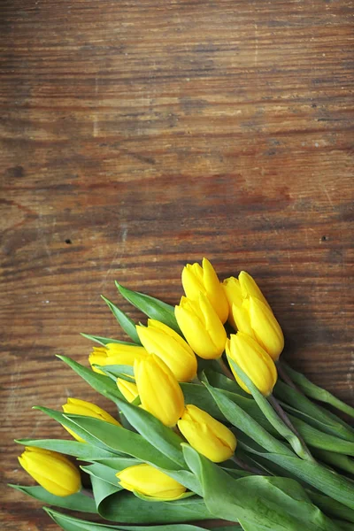 Um buquê de tulipas amarelas num vaso no chão. Um presente para um w — Fotografia de Stock