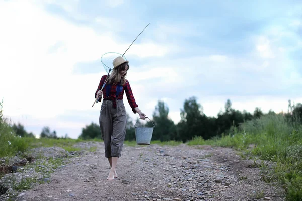 Flickan vid floden med ett fiskespö — Stockfoto