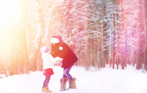 Зимняя сказка, молодая мать с дочерью катаются на санках — стоковое фото