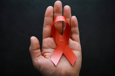 İnsan bağışıklık yetmezliği virüsü hastalığının sembolü. Kırmızı kurdele. Yardım eli ve destek. Arkaplan.
