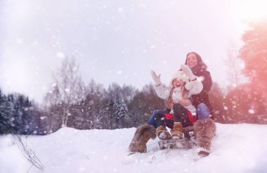Bir kış masal, genç bir anne ve kızı bir kızak sürmek