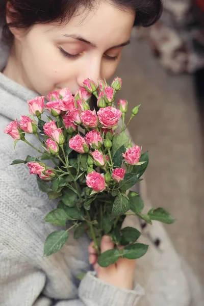 El ramo del arbusto de las rosas en las manos femeninas sobre el fondo — Foto de Stock