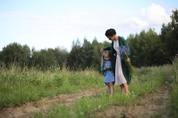 Mère avec sa fille marchant sur une route — Photo