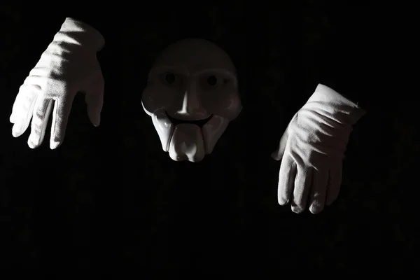Masque effrayant blanc sur fond noir avec main blanche . — Photo