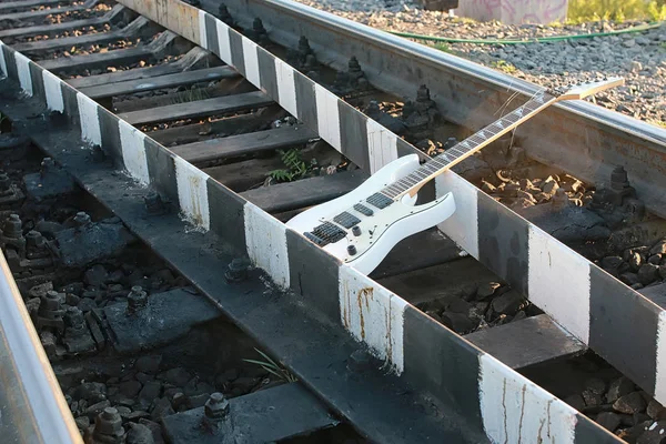 Guitare électrique blanche sur les voies ferrées et les pierres — Photo