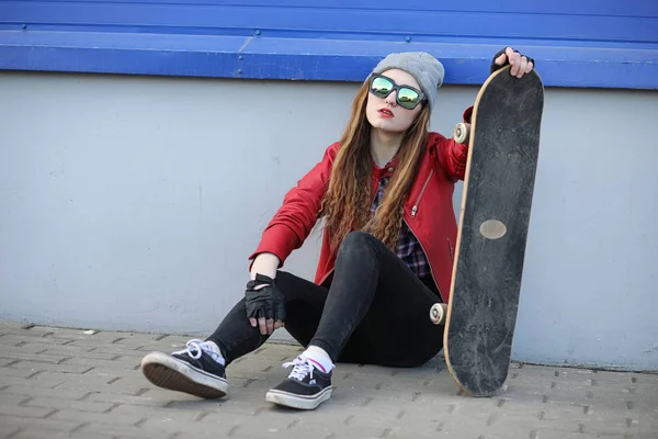 Una giovane hipster sta cavalcando uno skateboard. Ragazze amiche f — Foto Stock