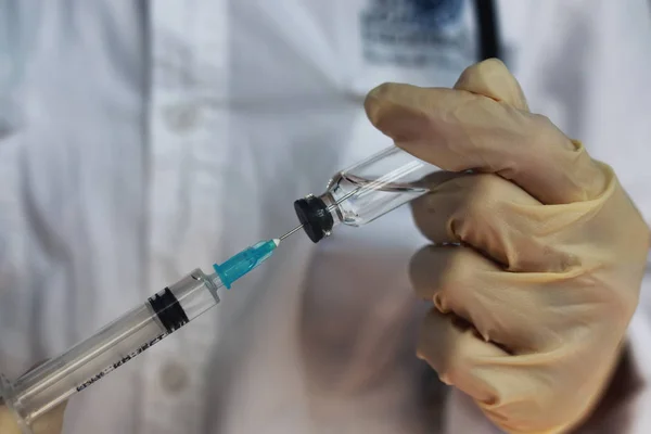 Nurse hands holding syringe and ampoule — Stock Photo, Image