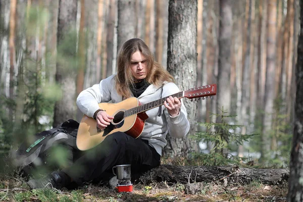 Guitarrista na floresta num piquenique. Um músico com um acústico — Fotografia de Stock