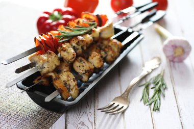 Beyaz masaya servis sebze ile metal şiş kebap pişmiş