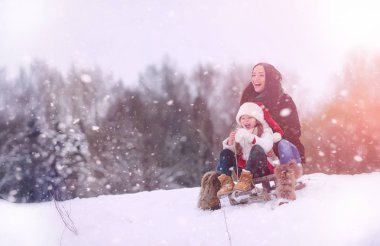 Bir kış masal, genç bir anne ve kızı bir kızak sürmek