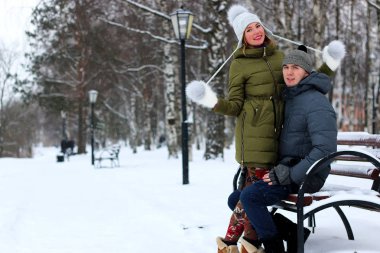 Genç bir çift kış parkında yürüyor.