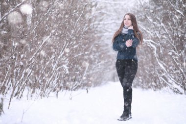 Kış parkında kar yağan bir kız