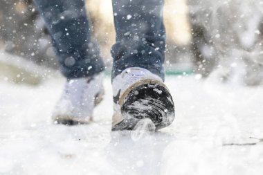 Karlı kış gününde bir adam şehirde yürüyor..