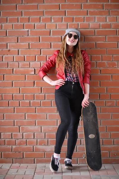 Ένα νεαρό hipster κορίτσι είναι ιππασίας ένα skateboard. Κορίτσια φίλες f — Φωτογραφία Αρχείου