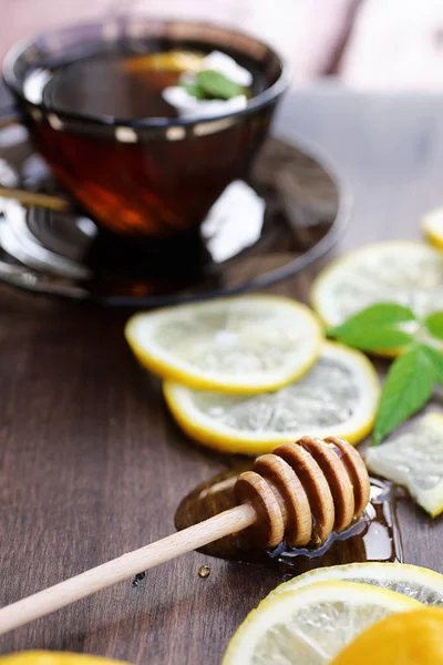 Frischer Honig mit einer Tasse Schwarztee — Stockfoto