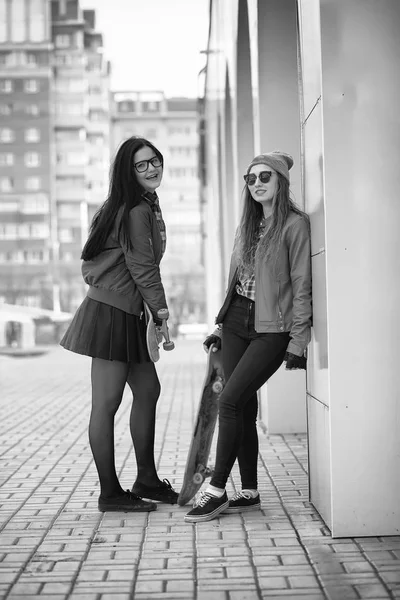 Uma jovem hipster está montando um skate. Meninas namoradas f — Fotografia de Stock