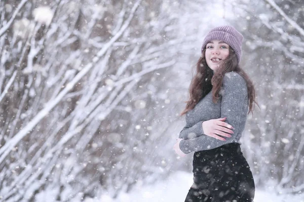 Girl in a winter park in snowfall — Stok Foto