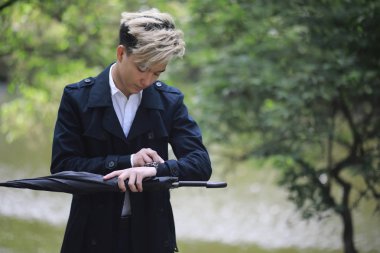 Bahar yağmurlu hava ve bir şemsiye ile genç bir adam