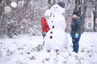 Çocuklar parkta ilk kar yürümek