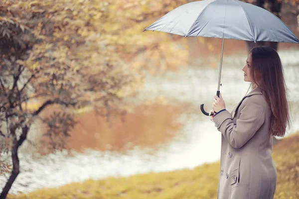 Autumn rainy weather and a young man with an umbrella — Stock Photo, Image