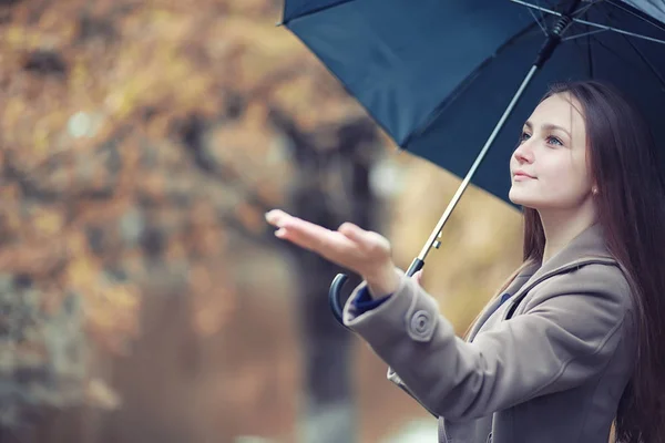 Φθινοπωρινό βροχερό καιρό και ένας νεαρός άνδρας με μια ομπρέλα — Φωτογραφία Αρχείου