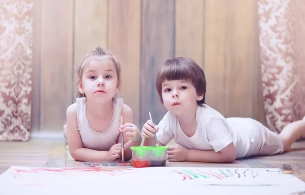 Little children paint on a large sheet of paper — Stock Photo, Image