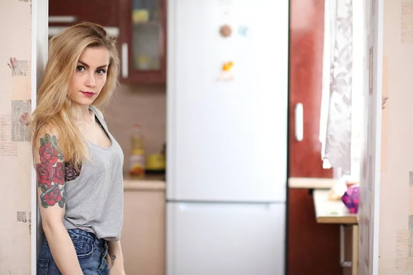 Uma menina bonita na cozinha prepara comida — Fotografia de Stock