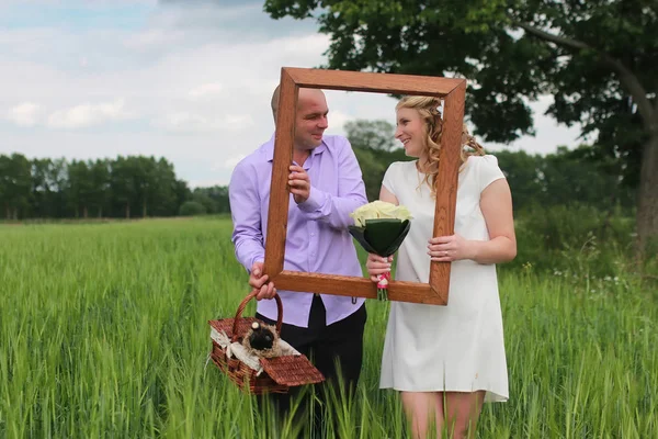 Pár milenců chůze v poli v letním dni — Stock fotografie