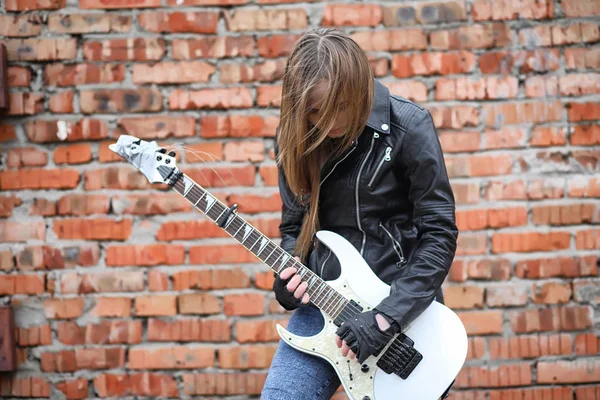 A rock musician girl in a leather jacket with a guitar — Stock Photo, Image